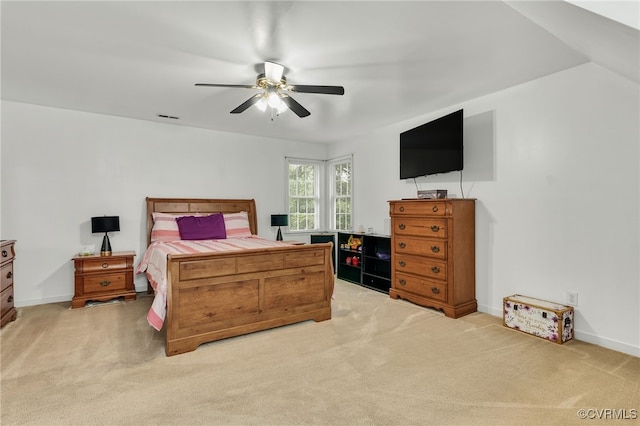 bedroom featuring light carpet, a ceiling fan, and baseboards