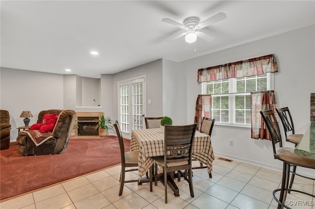 dining space with light tile patterned floors, a tiled fireplace, recessed lighting, baseboards, and a ceiling fan