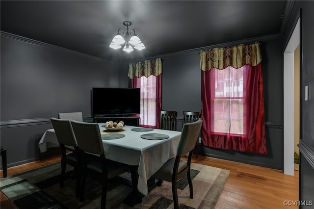 dining room featuring crown molding, a chandelier, and wood finished floors