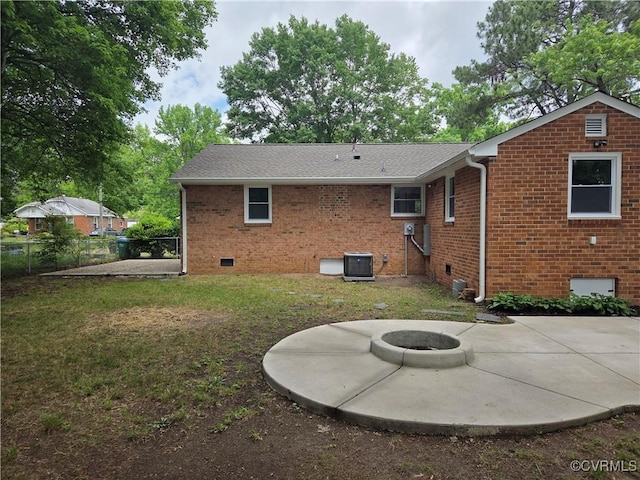 back of property with a patio, central air condition unit, an outdoor fire pit, brick siding, and crawl space