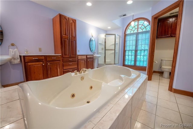 319 Parrotts Cove Rd, Water View, VA 23180 - bathroom featuring toilet, tile patterned flooring, a jetted tub, a shower stall, and baseboards