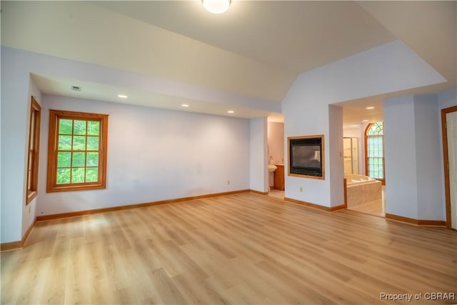 319 Parrotts Cove Rd, Water View, VA 23180 - unfurnished living room with healthy amount of natural light, light wood-type flooring, a multi sided fireplace, baseboards, and recessed lighting