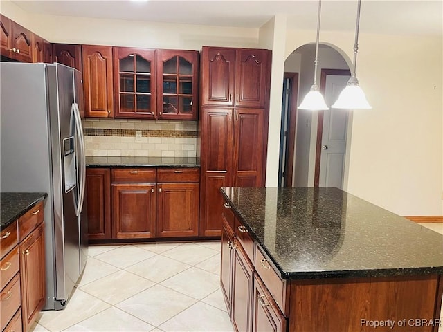 319 Parrotts Cove Rd, Water View, VA 23180 - kitchen featuring stainless steel refrigerator with ice dispenser, arched walkways, decorative backsplash, a center island, and light tile patterned flooring