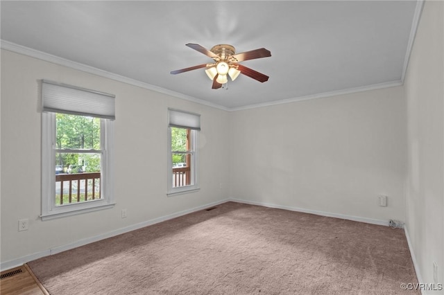carpeted spare room with a ceiling fan, crown molding, and baseboards