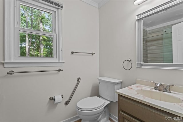 bathroom featuring toilet, vanity, crown molding, and baseboards