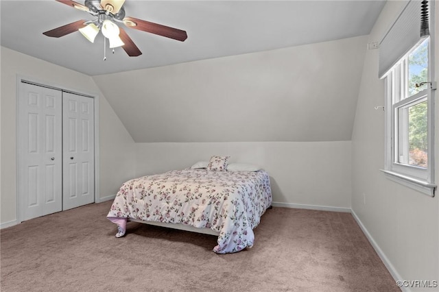 carpeted bedroom featuring lofted ceiling, a ceiling fan, baseboards, and a closet