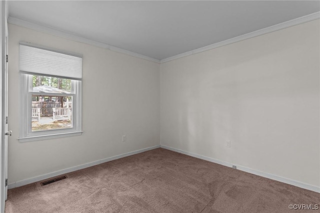 carpeted spare room with ornamental molding and baseboards