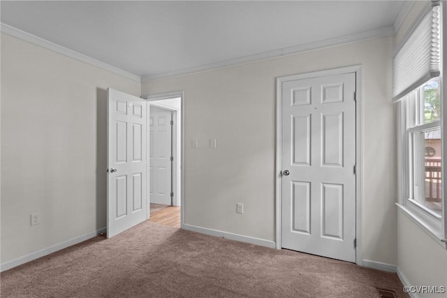unfurnished bedroom featuring carpet flooring, crown molding, and baseboards