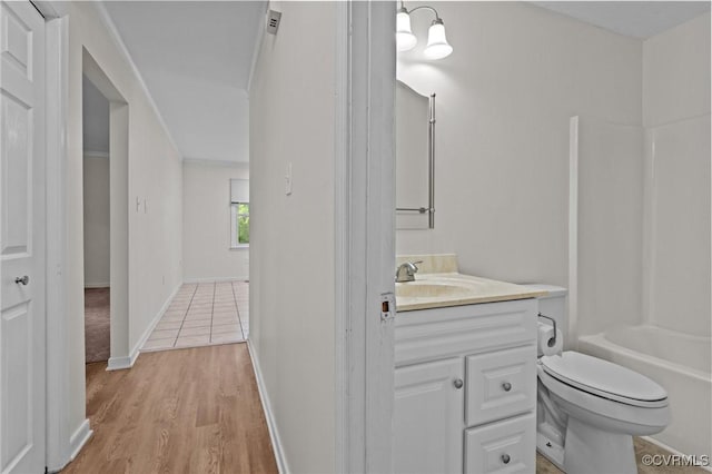 full bathroom featuring toilet, vanity, wood finished floors, baseboards, and shower / washtub combination