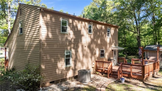rear view of house featuring a wooden deck, crawl space, and central air condition unit