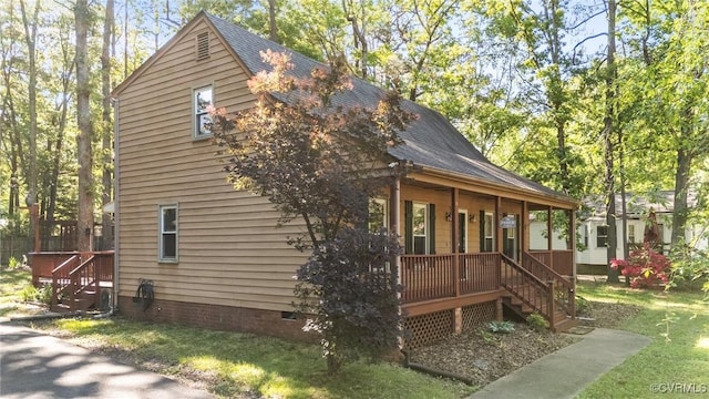 view of home's exterior featuring a porch, crawl space, stairway, and a yard