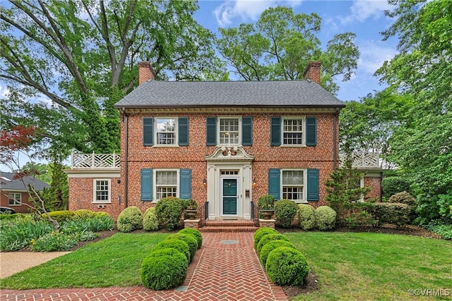 204 College Ave, Ashland, VA 23005 - colonial house featuring a chimney, a front yard, and brick siding