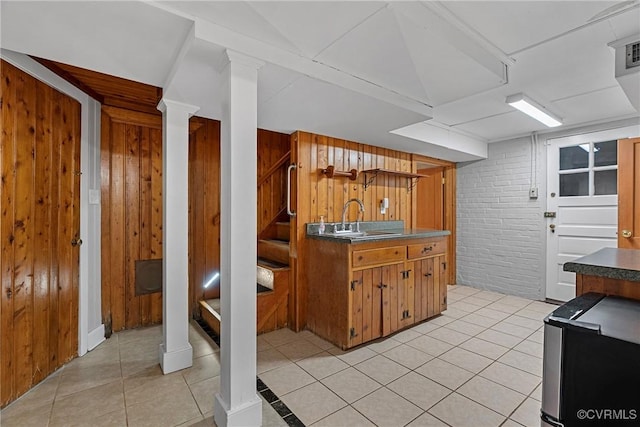 204 College Ave, Ashland, VA 23005 - kitchen with light tile patterned floors, brown cabinets, brick wall, and dark countertops