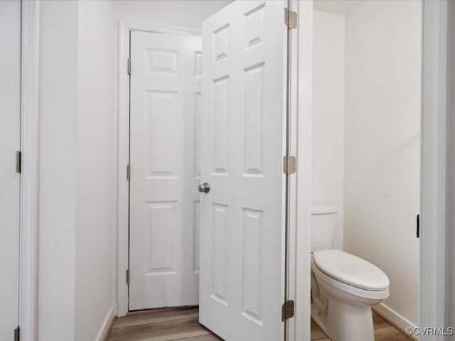 bathroom featuring wood finished floors, toilet, and baseboards