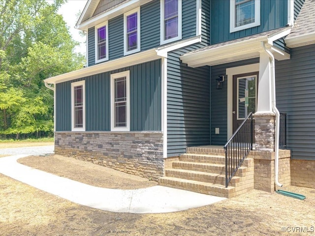 entrance to property with board and batten siding and stone siding