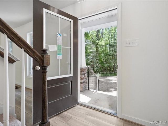 entrance foyer featuring stairs and light wood finished floors