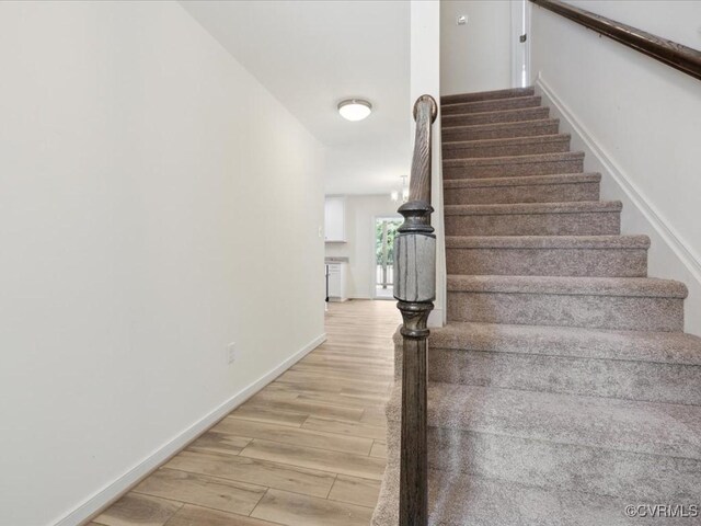 stairs featuring wood finished floors and baseboards