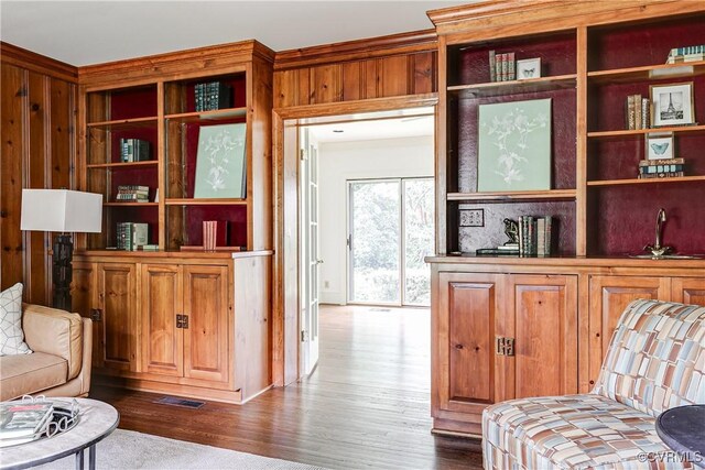 sitting room featuring wood finished floors and wooden walls