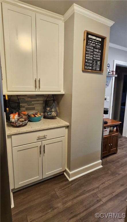 bar area featuring ornamental molding, dark wood finished floors, and backsplash