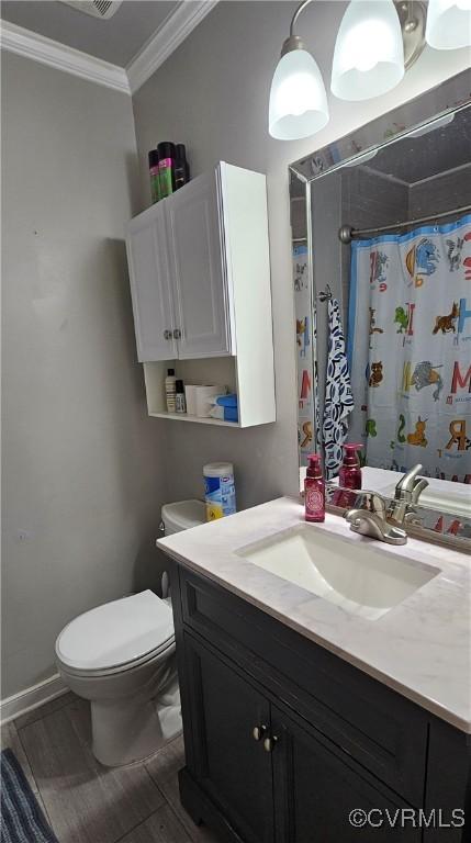 full bathroom with crown molding, toilet, wood finished floors, vanity, and a shower with shower curtain