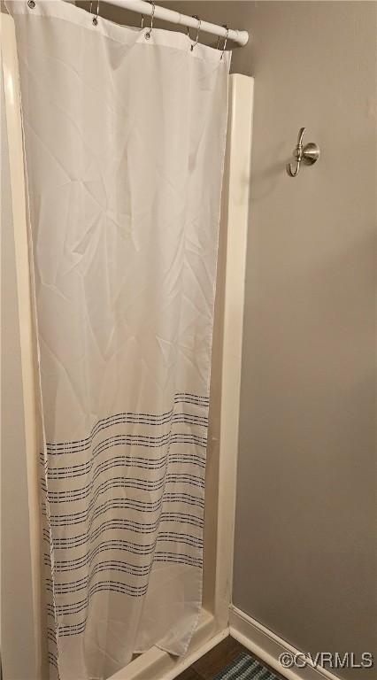 full bath featuring a shower with curtain and baseboards