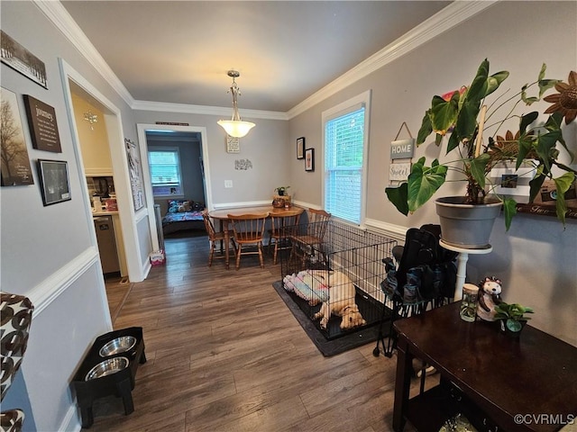 dining space with wood finished floors and ornamental molding