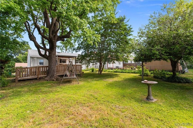 view of green lawn with a wooden deck