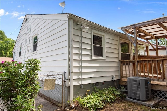 view of property exterior with central AC, a pergola, and a deck