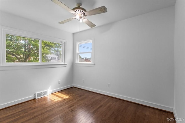 spare room featuring dark wood-style floors, baseboards, and ceiling fan