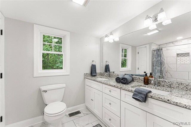 5541 Cedar Ln, Amelia Courthouse, VA 23002 - bathroom with baseboards, marble look tiles, toilet, a tile shower, and double vanity