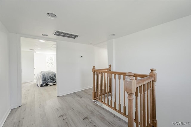 hallway featuring an upstairs landing, wood finished floors, recessed lighting, and baseboards