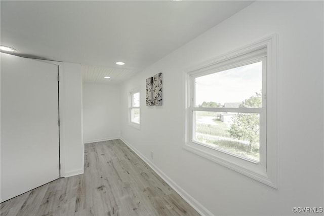 corridor featuring light wood-style floors, recessed lighting, and baseboards