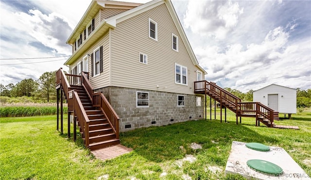 back of house with stairs, a lawn, a deck, an outbuilding, and crawl space