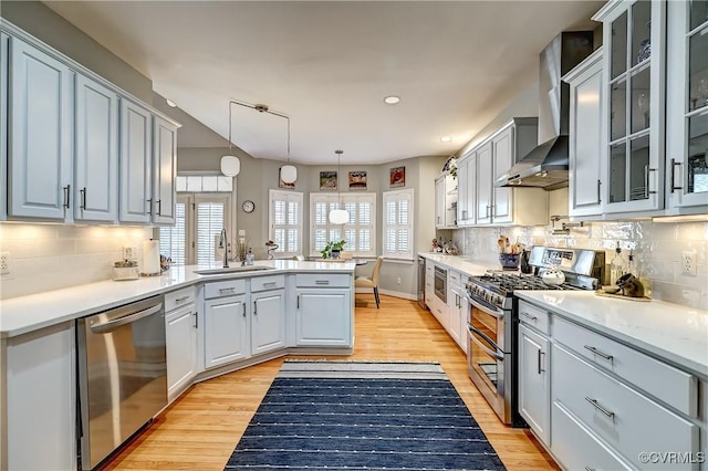 645 Farnham Cir, North Chesterfield, VA 23236 - kitchen featuring appliances with stainless steel finishes, a sink, wall chimney exhaust hood, a peninsula, and light wood-type flooring