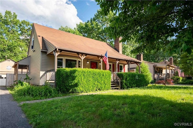 9323 Edington Dr, North Chesterfield, VA 23237 - view of front of house with covered porch, a chimney, a front yard, and an outbuilding