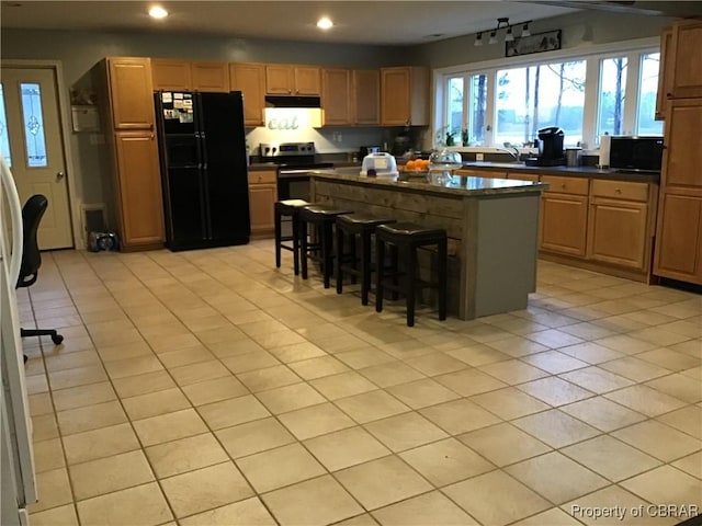 2577 Red Bank Rd, Ark, VA 23061 - kitchen featuring freestanding refrigerator, dark countertops, recessed lighting, a kitchen island, and light tile patterned floors