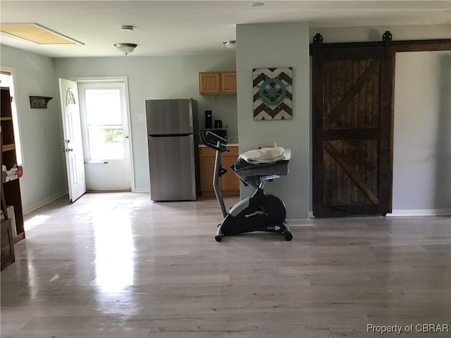 2577 Red Bank Rd, Ark, VA 23061 - kitchen with freestanding refrigerator, a barn door, baseboards, and light wood-style flooring