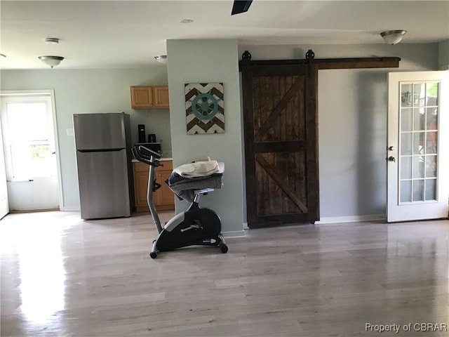 2577 Red Bank Rd, Ark, VA 23061 - dining area with a barn door, light wood finished floors, and baseboards