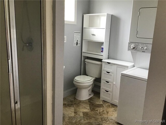 2577 Red Bank Rd, Ark, VA 23061 - full bathroom featuring stacked washer / drying machine, toilet, stone finish floors, baseboards, and a stall shower