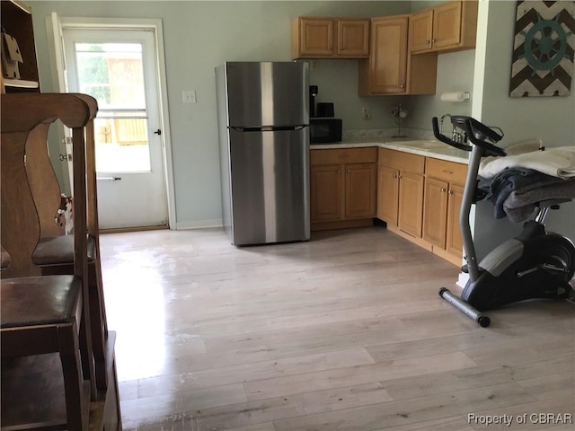 2577 Red Bank Rd, Ark, VA 23061 - kitchen featuring freestanding refrigerator, black microwave, light countertops, light wood-style flooring, and light brown cabinets