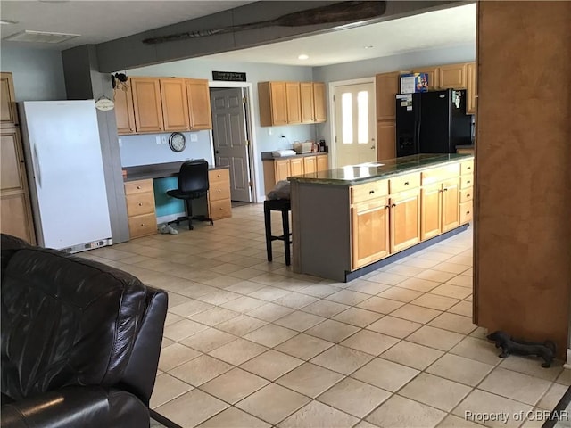 2577 Red Bank Rd, Ark, VA 23061 - kitchen featuring freestanding refrigerator, dark countertops, a breakfast bar area, light tile patterned floors, and recessed lighting