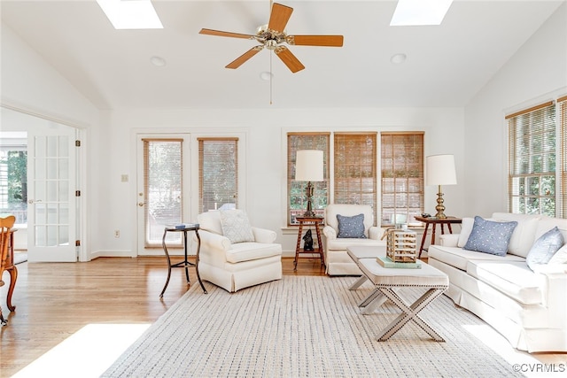 9905 Carrington Pl, Henrico, VA 23238 - living area with vaulted ceiling, a skylight, light wood-style flooring, a ceiling fan, and baseboards