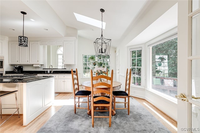 9905 Carrington Pl, Henrico, VA 23238 - dining space featuring light wood finished floors, a skylight, and lofted ceiling