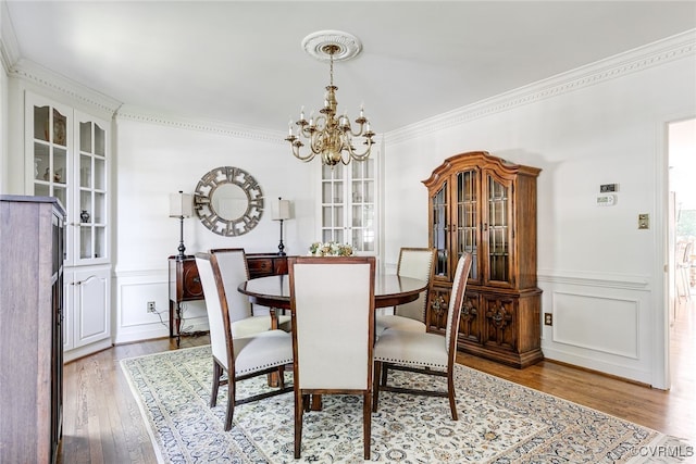 9905 Carrington Pl, Henrico, VA 23238 - dining room featuring wood finished floors, a chandelier, crown molding, a decorative wall, and a wainscoted wall