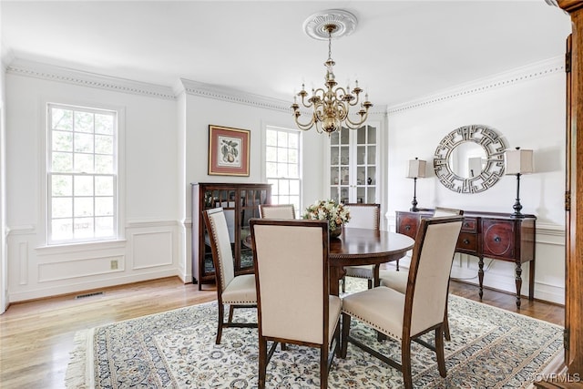 9905 Carrington Pl, Henrico, VA 23238 - dining room with a chandelier, healthy amount of natural light, light wood-style flooring, ornamental molding, and wainscoting
