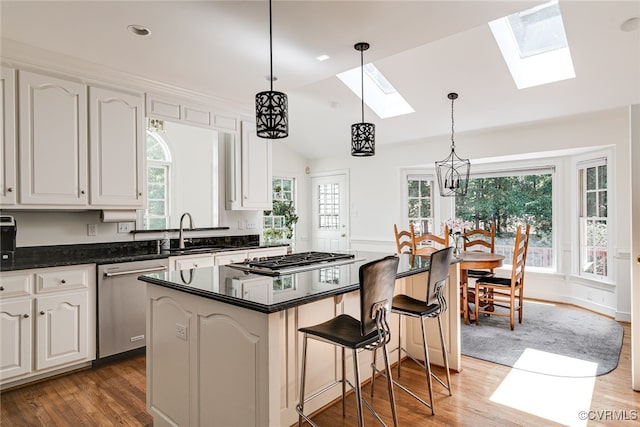 9905 Carrington Pl, Henrico, VA 23238 - kitchen featuring appliances with stainless steel finishes, a skylight, a sink, lofted ceiling, and wood finished floors