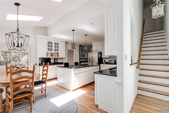 9905 Carrington Pl, Henrico, VA 23238 - kitchen with dark countertops, light wood finished floors, a chandelier, white cabinetry, and recessed lighting