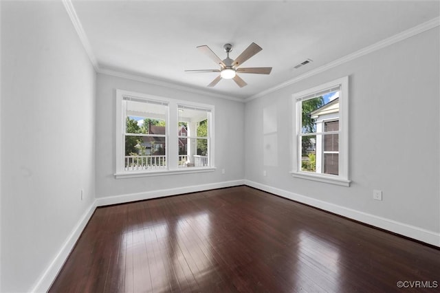 empty room featuring healthy amount of natural light, hardwood / wood-style flooring, ceiling fan, baseboards, and crown molding