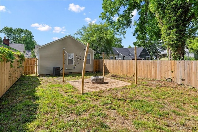 view of yard with a fire pit, cooling unit, and a patio