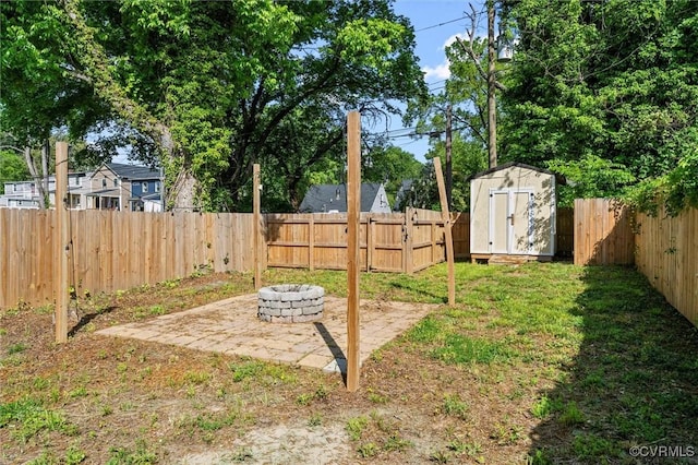 view of yard with a fire pit, a storage unit, a patio, and an outdoor structure
